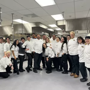 Chefs and Cooks pose in the kitchen at MBCC